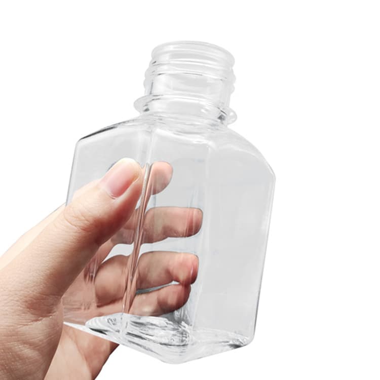 Clear polycarbonate square media bottle held by hand